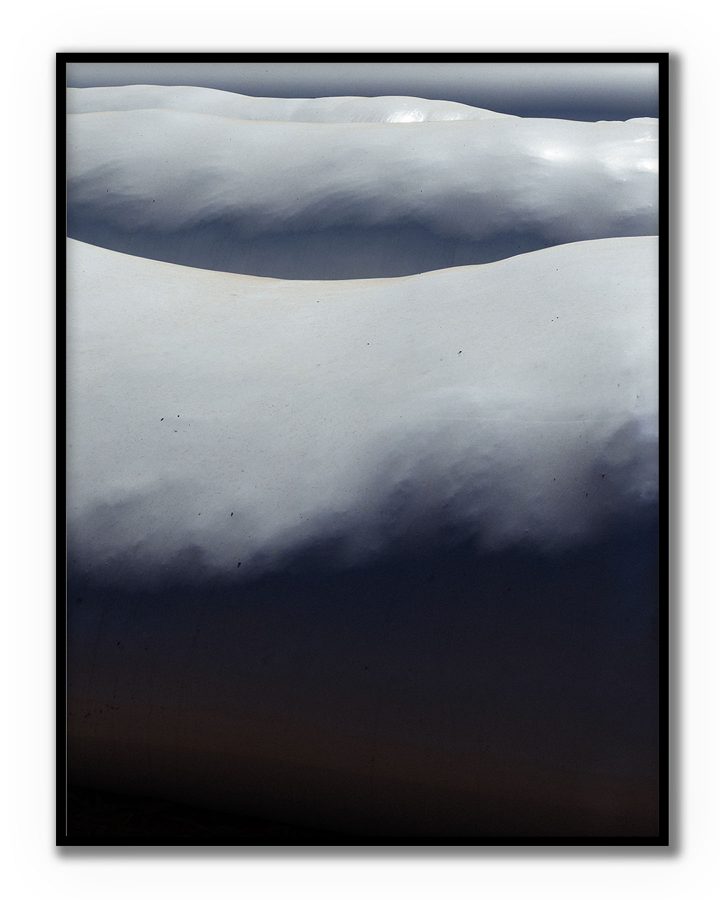 Capas de nieve formando líneas suaves en una fotografía minimalista de BORRO.